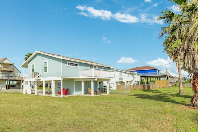 rear view of house featuring a patio, a balcony, and a yard