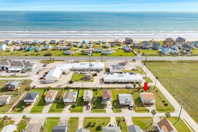 drone / aerial view featuring a beach view and a water view