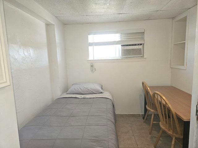 tiled bedroom featuring cooling unit and a paneled ceiling