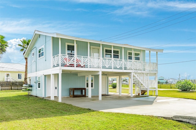 rear view of house with a carport, a porch, and a yard