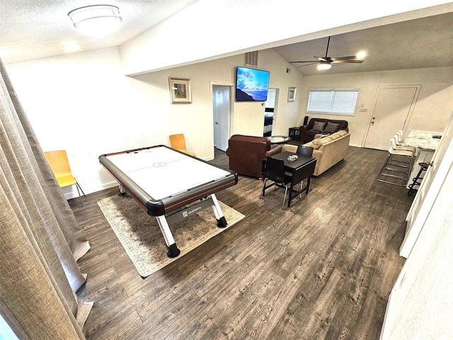 rec room with vaulted ceiling, a textured ceiling, ceiling fan, and dark hardwood / wood-style flooring