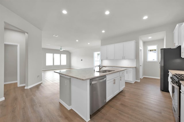 kitchen featuring white cabinets, a wealth of natural light, an island with sink, and appliances with stainless steel finishes