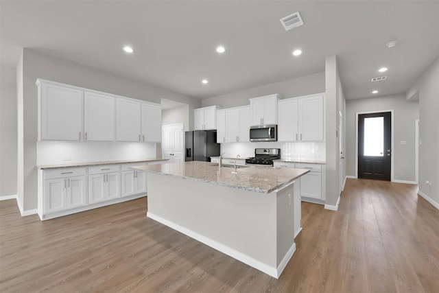 kitchen featuring white cabinets, appliances with stainless steel finishes, and light wood-type flooring