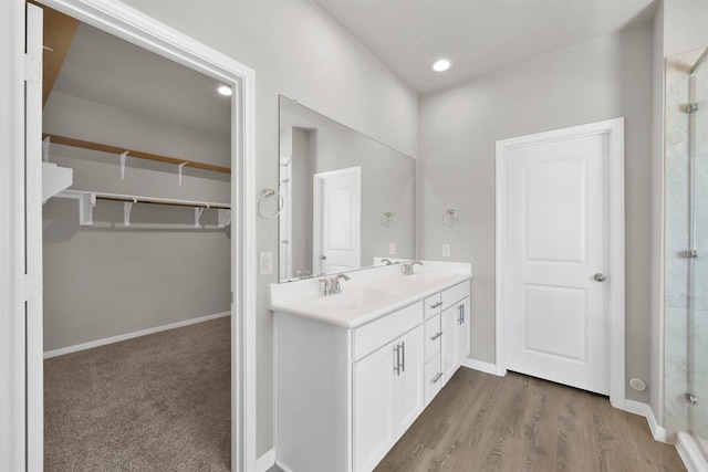 bathroom with a shower with door, vanity, and wood-type flooring