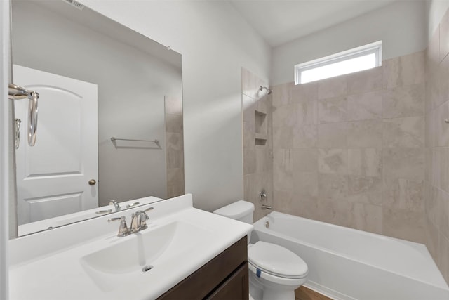 full bathroom with tiled shower / bath combo, toilet, and vanity