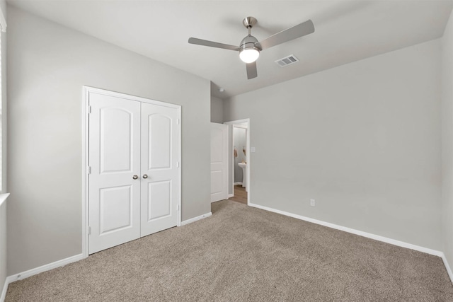 unfurnished bedroom with ceiling fan, a closet, and carpet