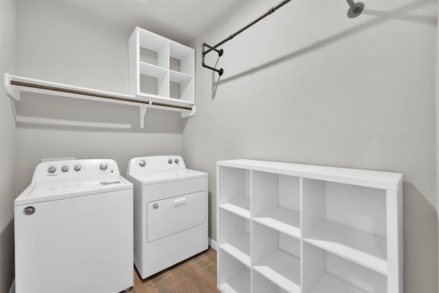 laundry room with separate washer and dryer and light hardwood / wood-style floors