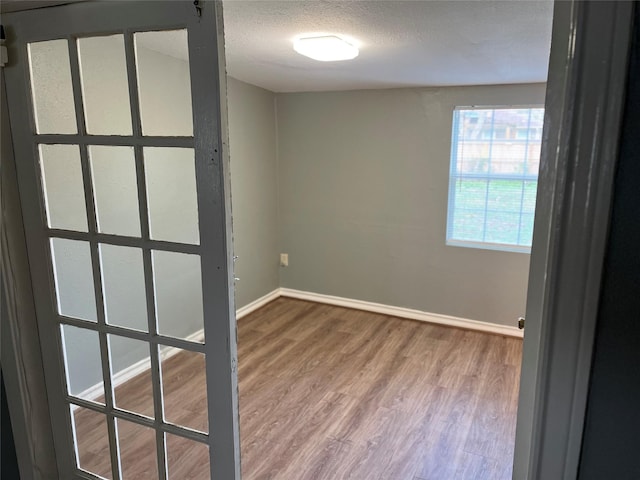 spare room with a textured ceiling and hardwood / wood-style flooring