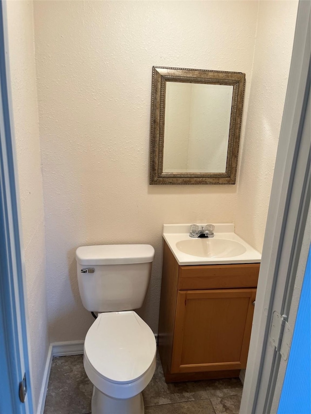 bathroom with toilet, vanity, and tile patterned floors