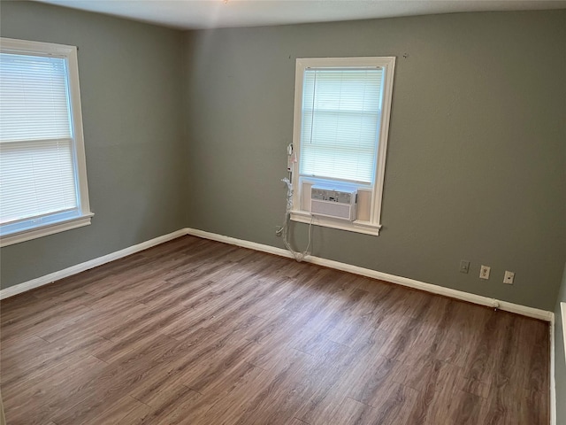 empty room featuring cooling unit and wood-type flooring