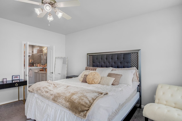 bedroom with ceiling fan, dark carpet, and ensuite bath