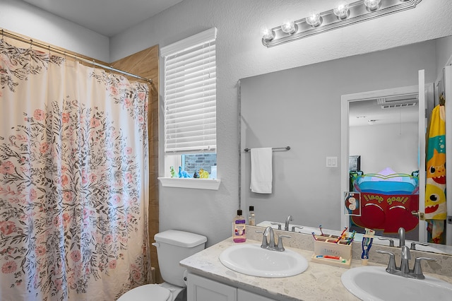 bathroom with walk in shower, vanity, and toilet