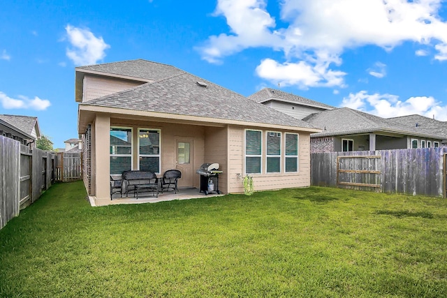 rear view of house with a yard and a patio