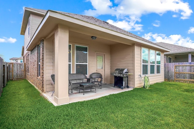 rear view of house with a lawn and a patio