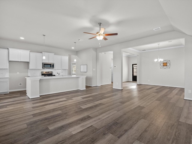 unfurnished living room featuring sink, ceiling fan with notable chandelier, and dark hardwood / wood-style floors