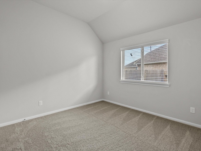 unfurnished room featuring carpet flooring and vaulted ceiling