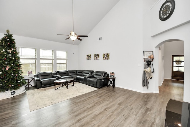 living room with ceiling fan, wood-type flooring, and high vaulted ceiling