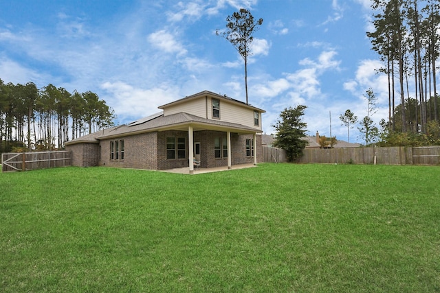 rear view of property with a lawn and a patio area