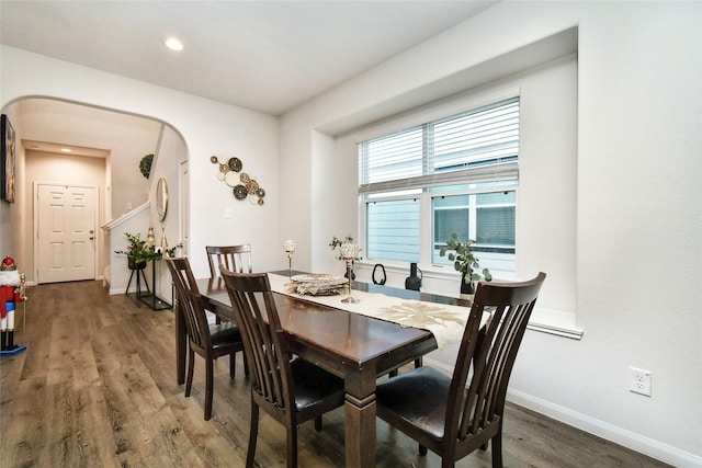 dining area featuring dark wood-style floors, baseboards, arched walkways, and recessed lighting