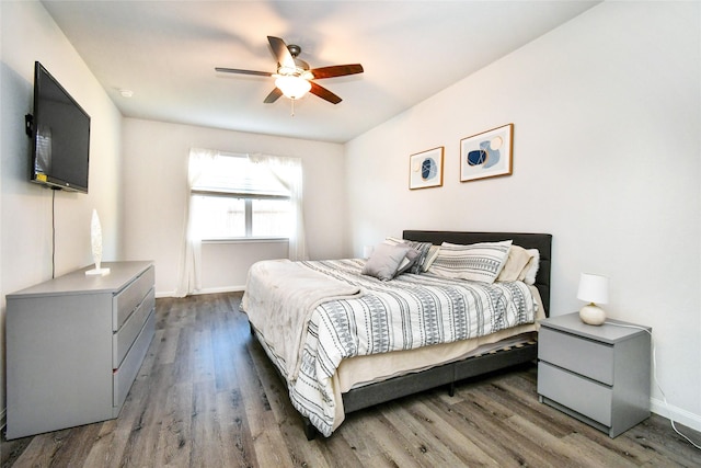 bedroom featuring ceiling fan, baseboards, and dark wood-style flooring