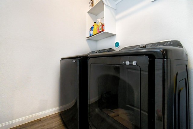 laundry area with laundry area, baseboards, separate washer and dryer, and wood finished floors