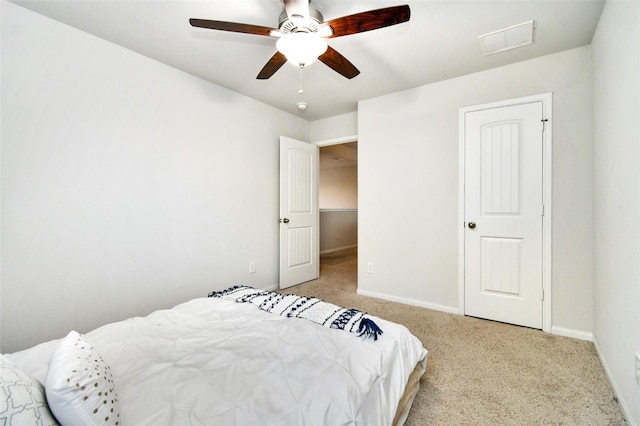 bedroom with light carpet, visible vents, baseboards, and ceiling fan