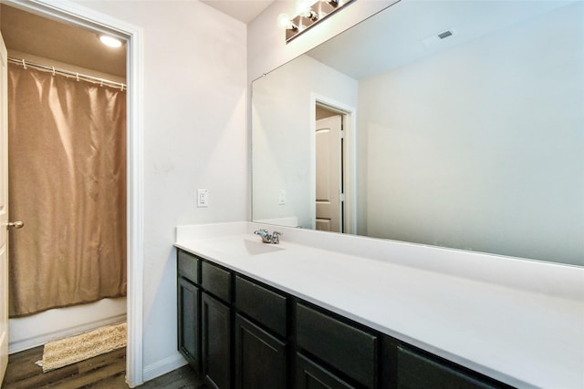 full bath with visible vents, shower / bathtub combination with curtain, vanity, wood finished floors, and baseboards