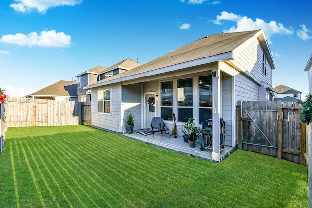 back of house with a yard, a patio, and fence