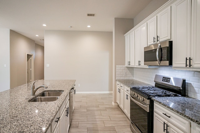 kitchen featuring light stone counters, white cabinets, and appliances with stainless steel finishes