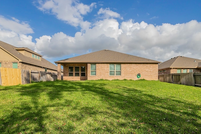 rear view of property with a lawn