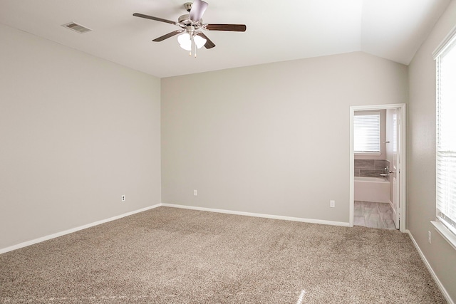 carpeted spare room with ceiling fan and vaulted ceiling