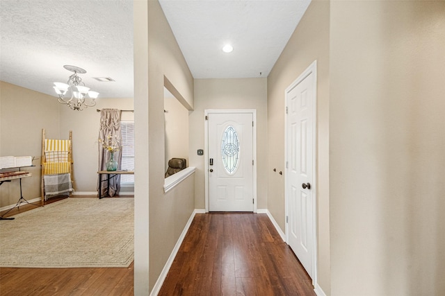 doorway featuring hardwood / wood-style flooring, a notable chandelier, and a textured ceiling