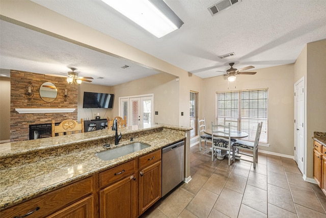 kitchen with a textured ceiling, dishwasher, and sink