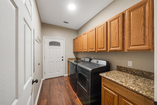 washroom with cabinets, independent washer and dryer, and dark wood-type flooring