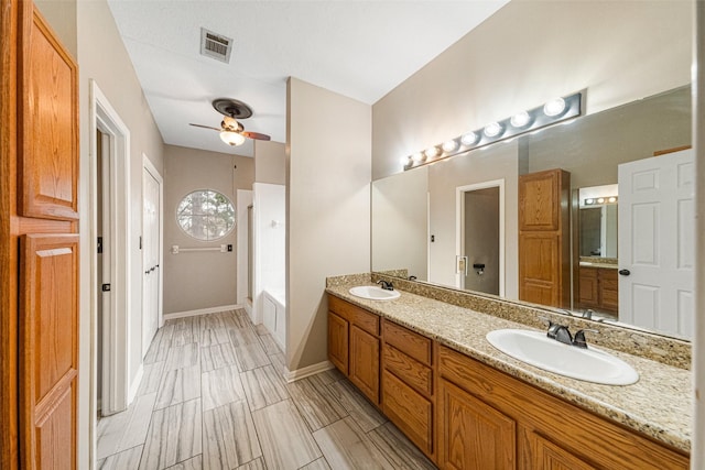 bathroom featuring ceiling fan, a bath, and vanity