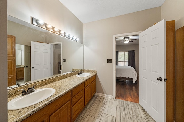 bathroom with ceiling fan, hardwood / wood-style floors, vanity, and a textured ceiling