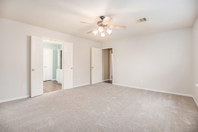 empty room featuring baseboards, carpet floors, visible vents, and a ceiling fan