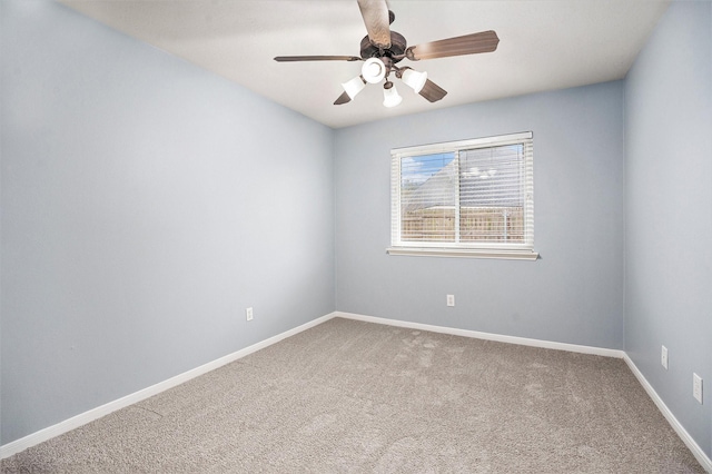 carpeted spare room featuring ceiling fan and baseboards