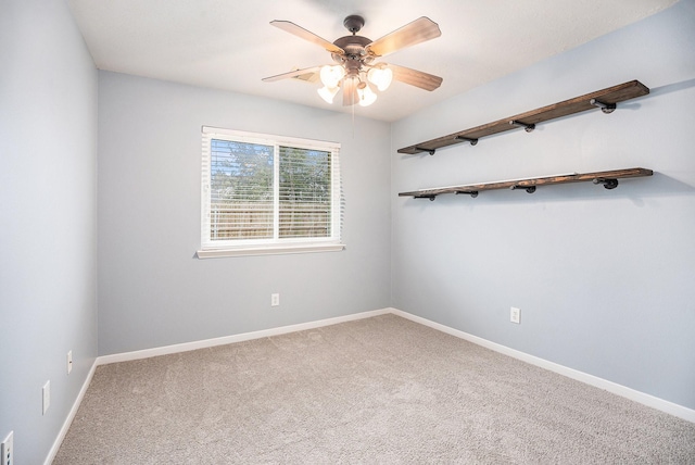 carpeted empty room with baseboards and a ceiling fan