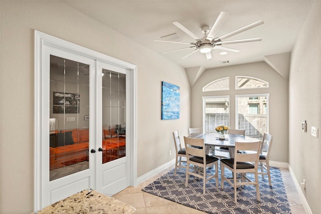 dining room featuring ceiling fan, french doors, light tile patterned floors, and lofted ceiling