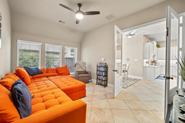 living room featuring ceiling fan, french doors, sink, vaulted ceiling, and light tile patterned flooring