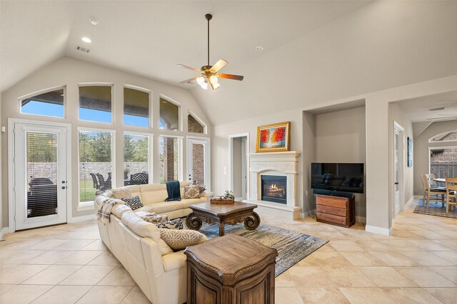 tiled living room with ceiling fan and high vaulted ceiling