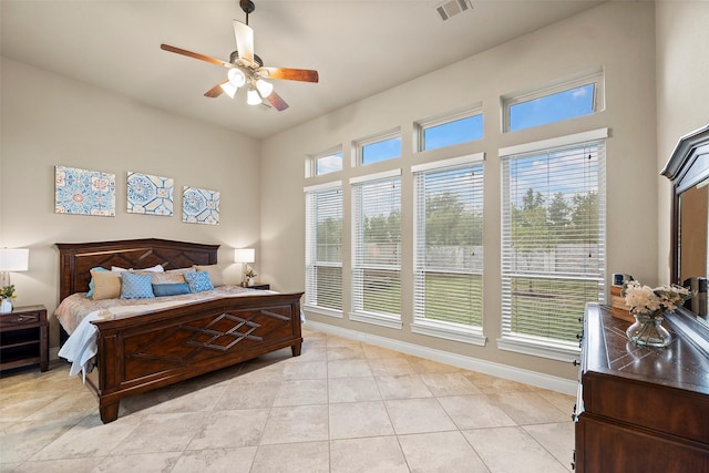 bedroom with light tile patterned floors, multiple windows, and ceiling fan