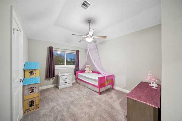 bedroom with a tray ceiling, ceiling fan, and light colored carpet