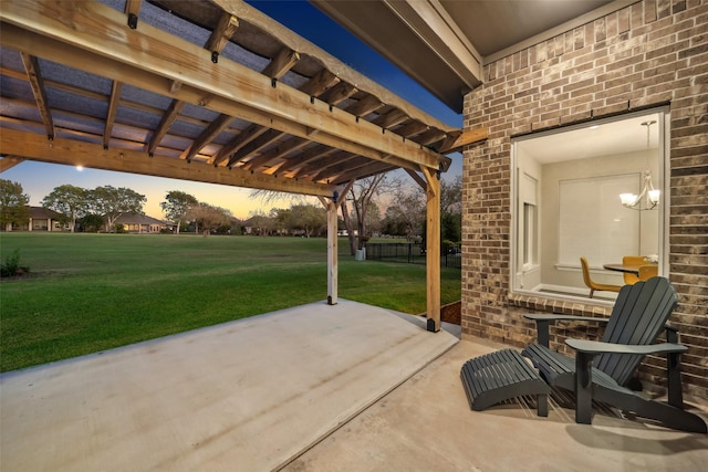 patio terrace at dusk with a pergola and a lawn