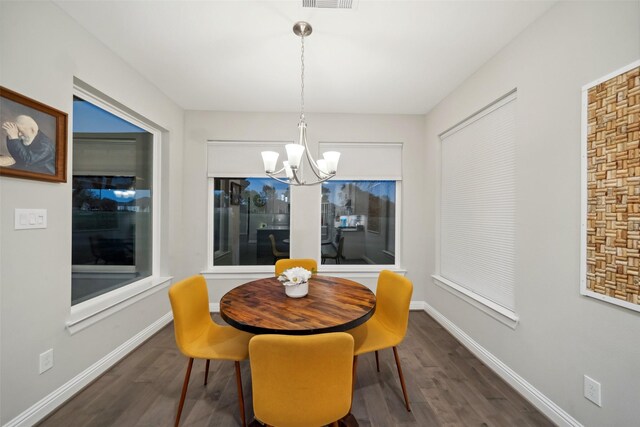 dining room featuring an inviting chandelier and dark wood-type flooring