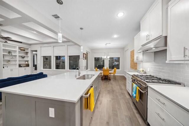 kitchen featuring appliances with stainless steel finishes, sink, white cabinetry, hanging light fixtures, and a large island