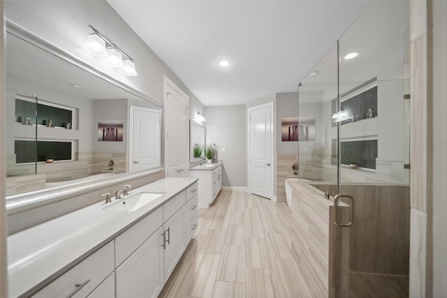 bathroom with vanity and independent shower and bath