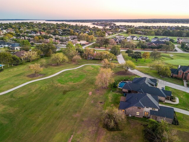 aerial view at dusk featuring a water view