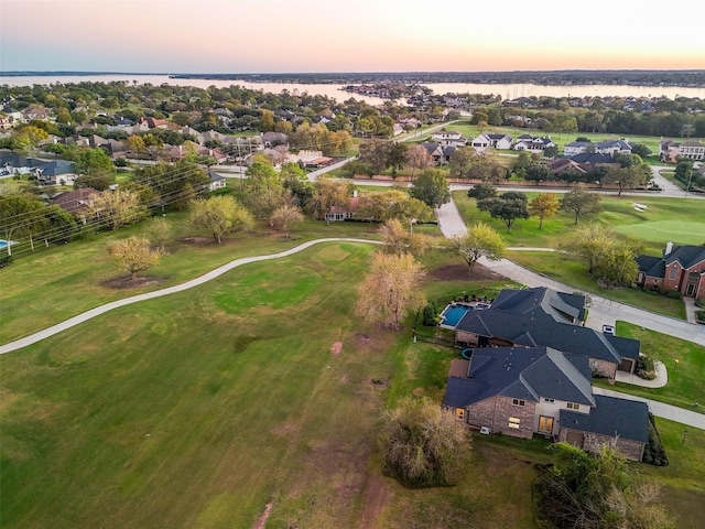 aerial view at dusk featuring a water view